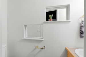 Half bathroom featuring vanity and toilet