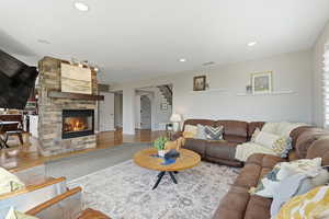 Living area with a fireplace, wood finished floors, and recessed lighting