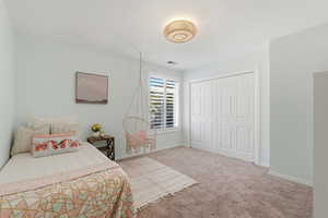 Bedroom featuring light colored carpet and a closet