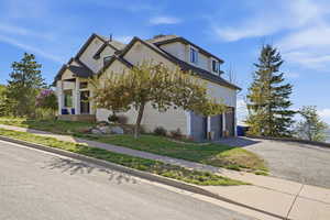 View of front of house with a garage, driveway, brick siding, and a front lawn