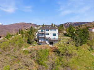 Back of property featuring a mountain view, stucco siding, and a balcony