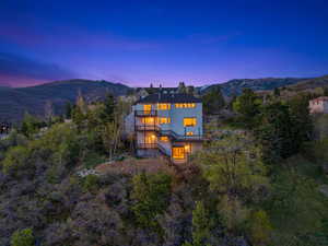 Back of house featuring a mountain view, a balcony, and stucco siding