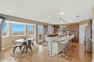 Kitchen with a kitchen island, a mountain view, a breakfast bar, light stone counters, and hanging light fixtures