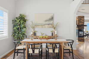 Dining space featuring wood finished floors and arched walkways