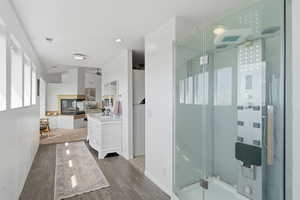 Full bathroom featuring a shower stall, vanity, and wood finished floors