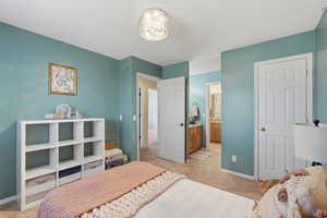 Bedroom featuring light colored carpet and connected bathroom