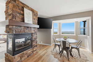 Dining area featuring light wood finished floors and a stone fireplace