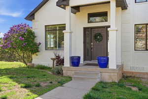 Doorway to property with brick siding and a yard