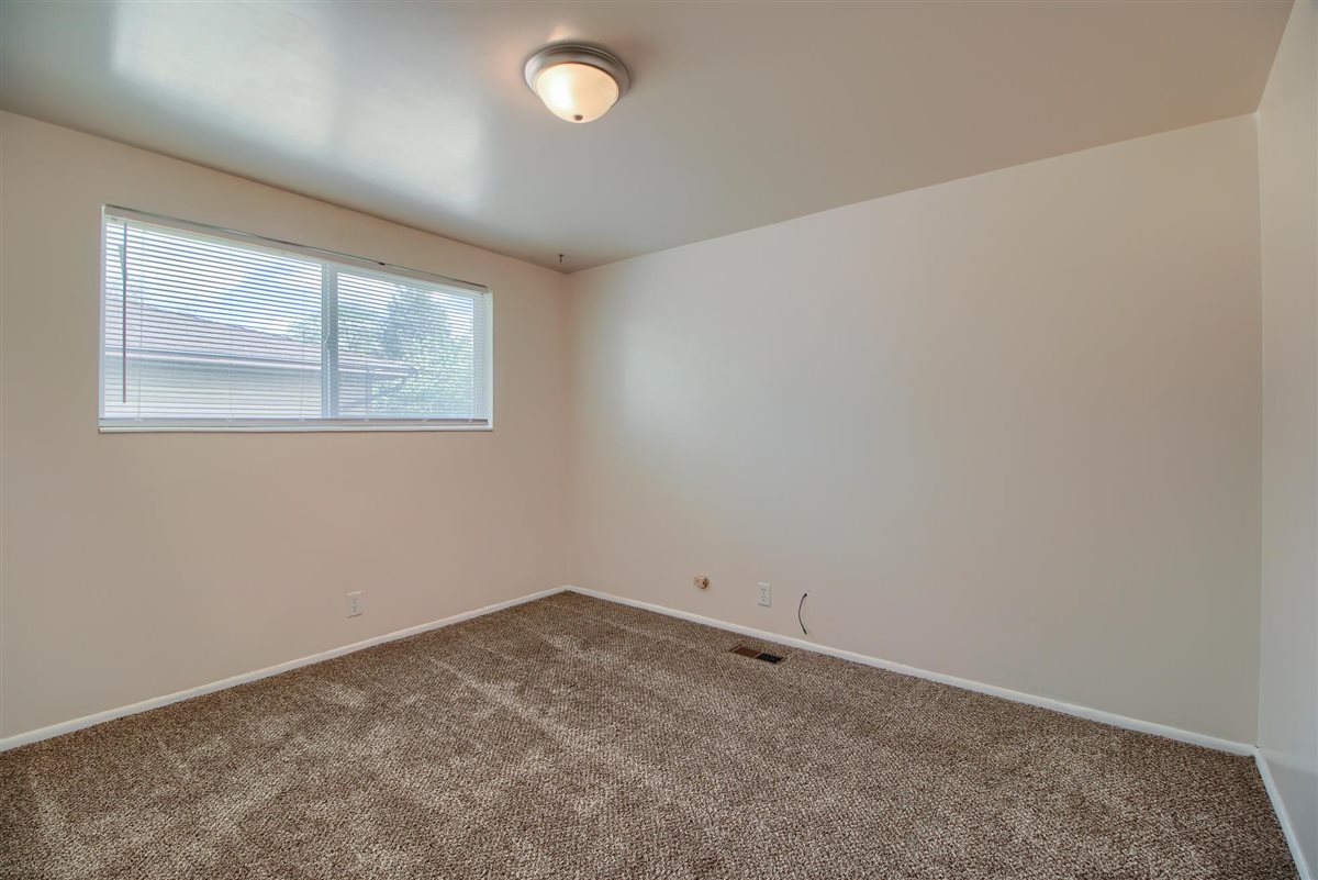 Empty room with dark carpet and baseboards