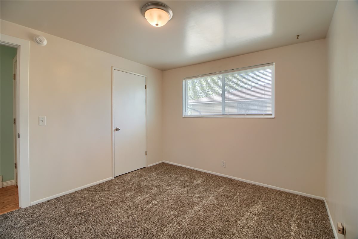 Unfurnished bedroom with carpet flooring and baseboards