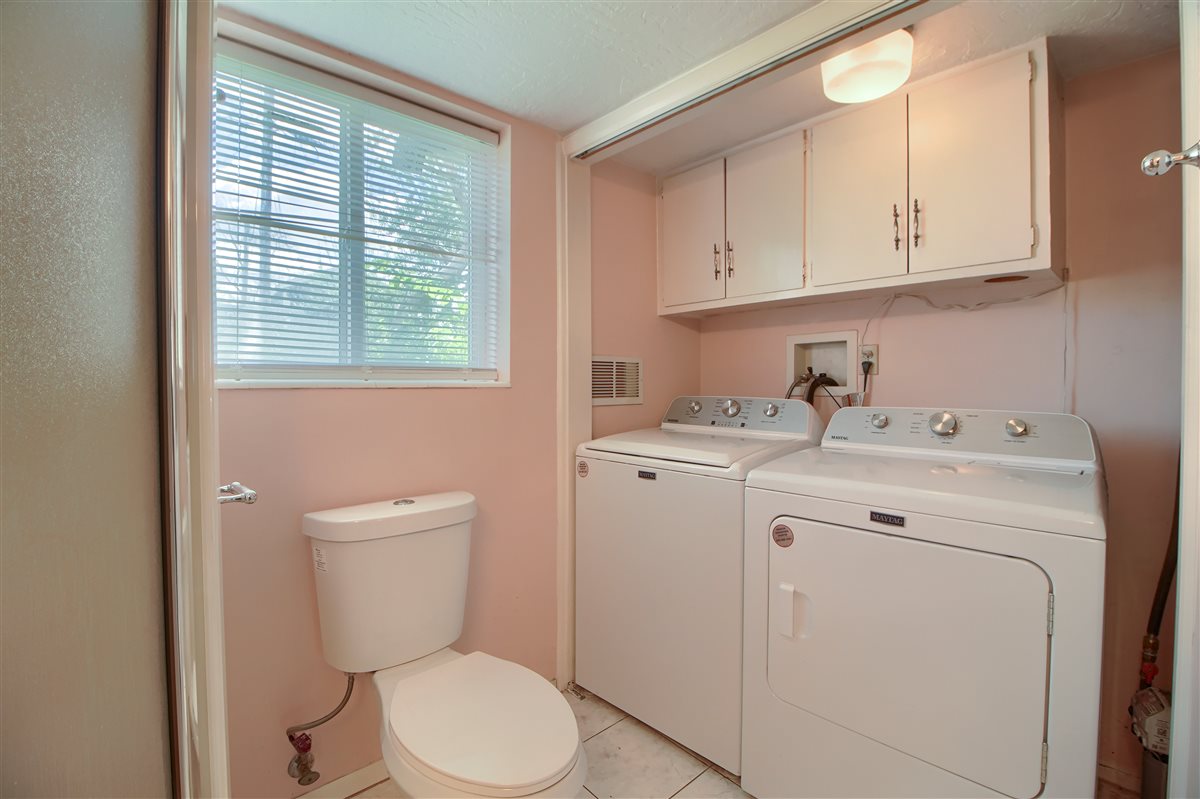 Bathroom with washing machine and clothes dryer and light tile patterned floors