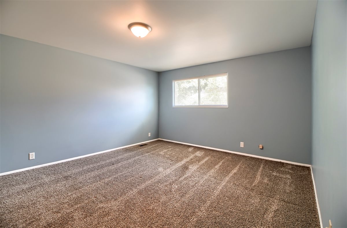 Unfurnished room featuring dark carpet and baseboards
