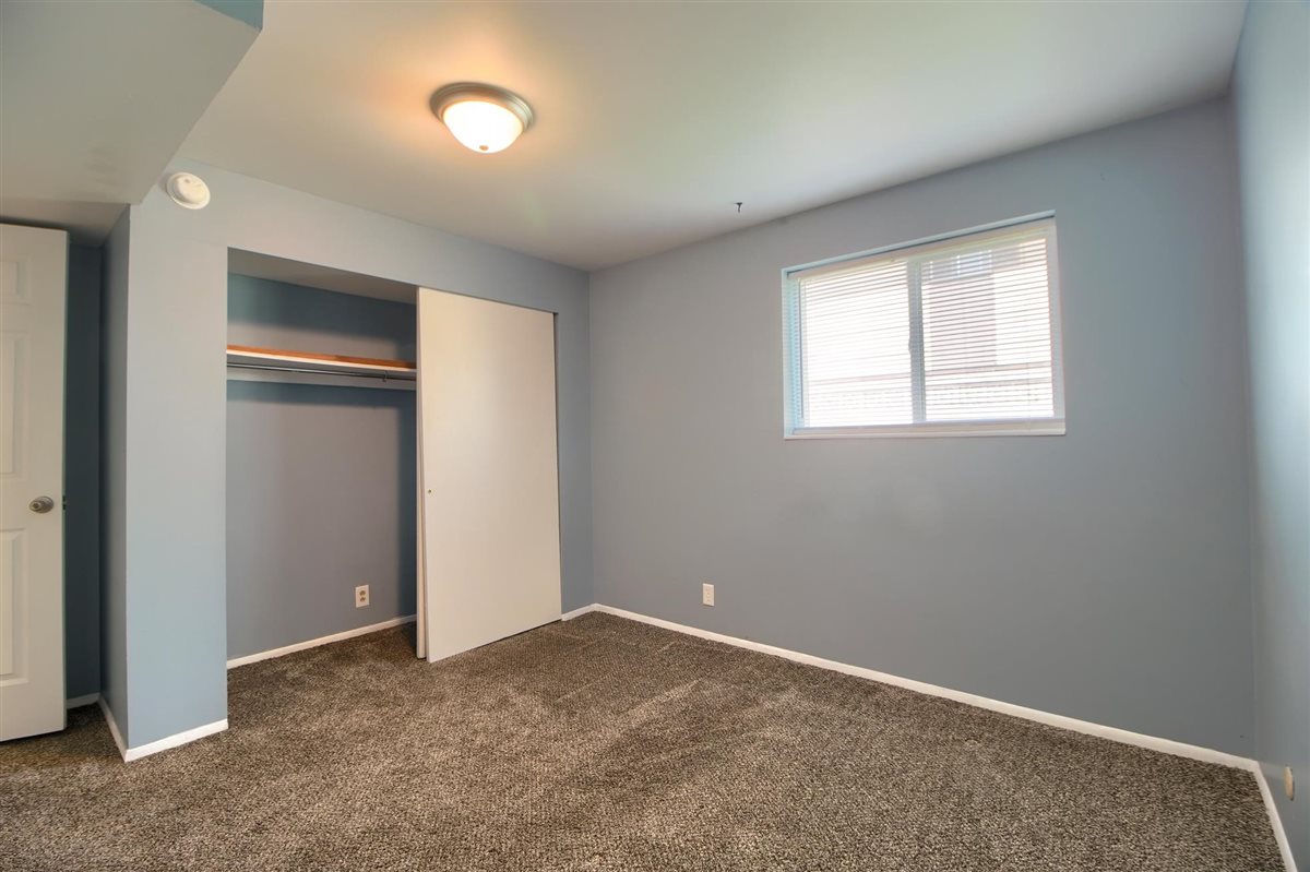 Unfurnished bedroom featuring dark colored carpet and a closet