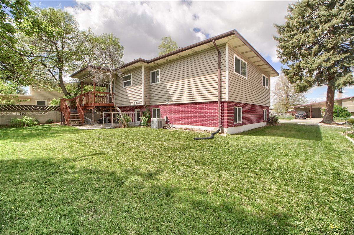 Back of house with a wooden deck and brick siding