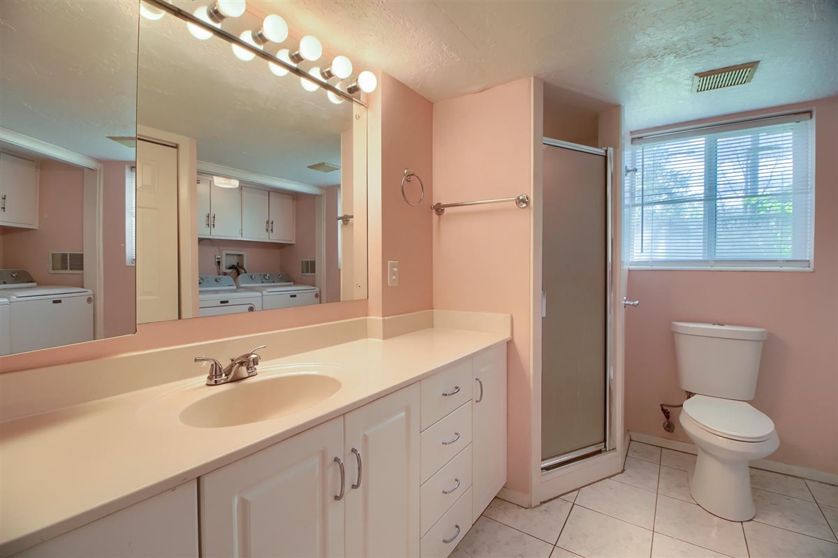 Bathroom with washing machine and clothes dryer, vanity, a shower stall, a textured ceiling, and light tile patterned floors