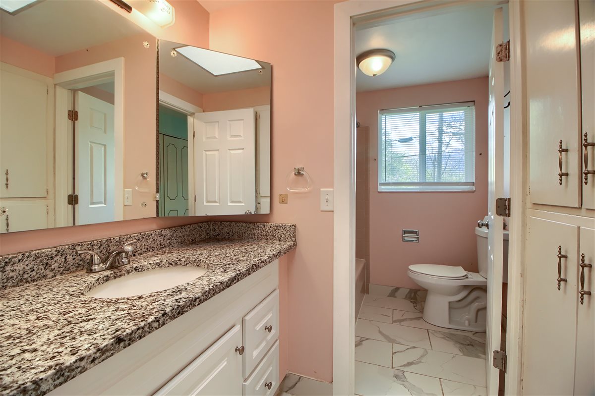 Bathroom with light marble finish floors, vanity, and tub / shower combination
