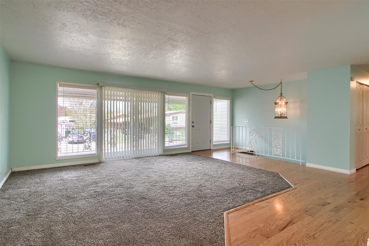 Unfurnished living room with a textured ceiling and light wood-type flooring