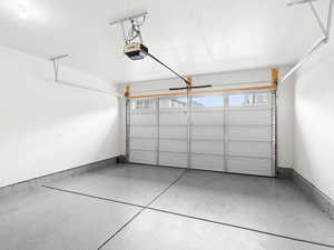 Garage with a garage door opener and baseboards
