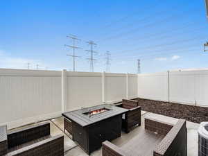 Fenced backyard with an outdoor living space with a fire pit and a patio