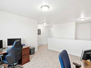 Office area featuring light carpet and baseboards