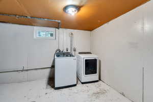 Laundry area featuring concrete flooring and washer and clothes dryer