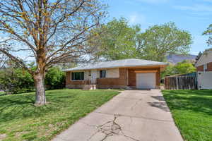 Ranch-style house featuring brick siding, a garage, and driveway