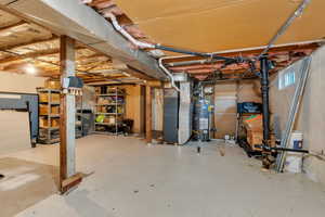 Below grade area featuring strapped water heater and heating unit