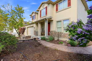 View of front of property with stone siding, stucco siding, and an attached garage