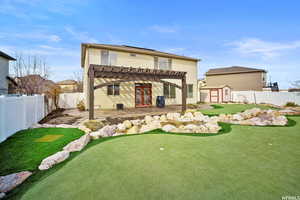 Rear view of property with a storage shed, a fenced backyard, a patio area, a pergola, and an area to practice putting