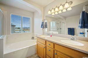 Bathroom with double vanity, a garden tub, and a stall shower