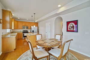 Dining area with light wood-type flooring, recessed lighting, and arched walkways