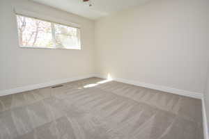 Unfurnished room with baseboards and light carpet