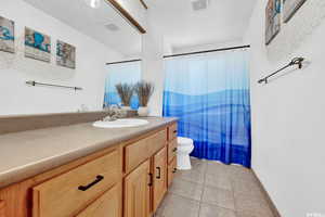 Full bathroom with vanity, curtained shower, and light tile patterned floors