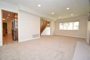 Spare room with crown molding, recessed lighting, and light colored carpet