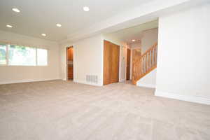 Unfurnished room featuring light colored carpet, ornamental molding, and recessed lighting
