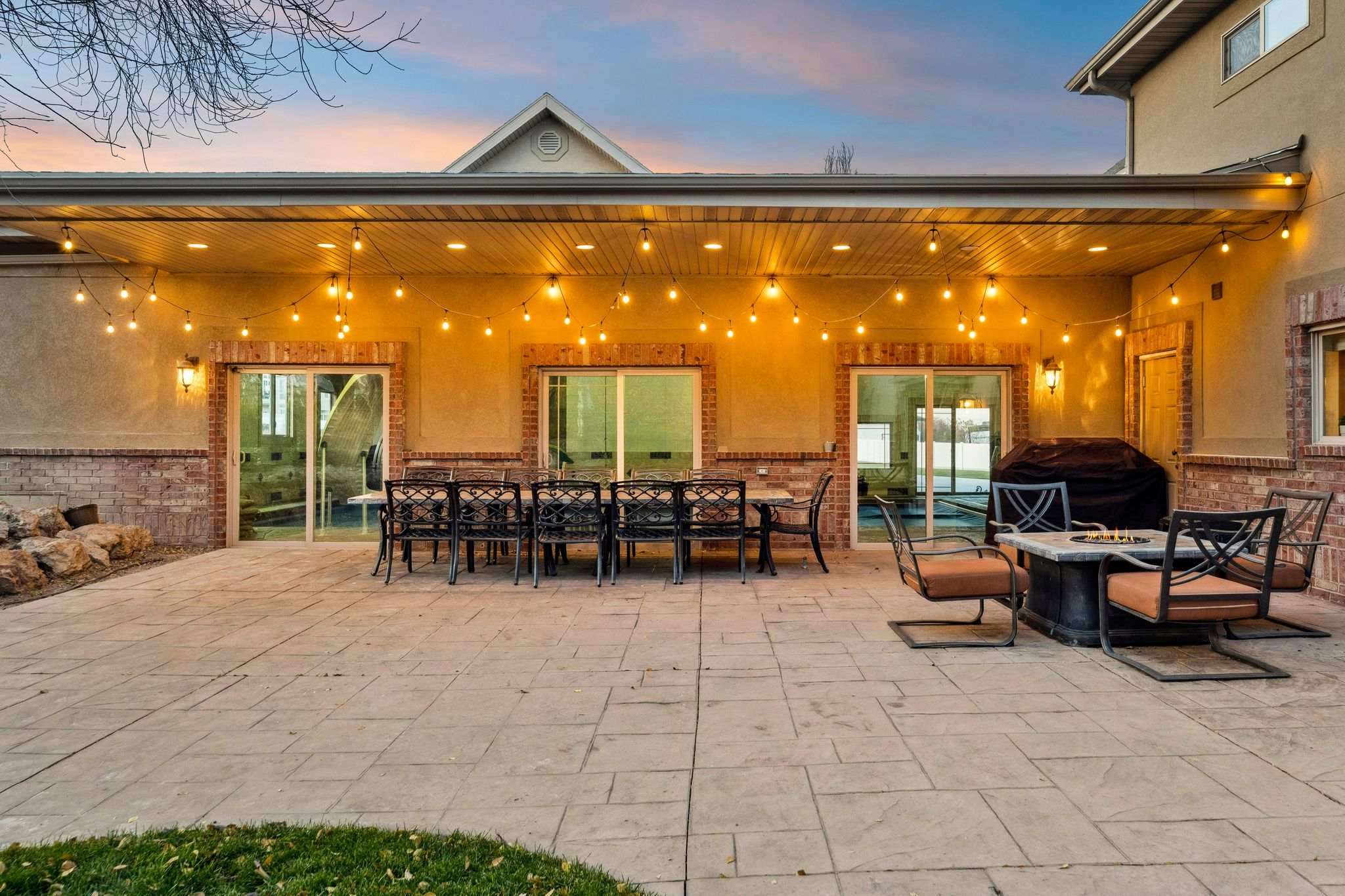 View of patio with outdoor dining space, a fire pit, and grilling area