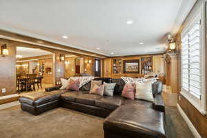 Living area with crown molding, arched walkways, carpet flooring, recessed lighting, and built in features