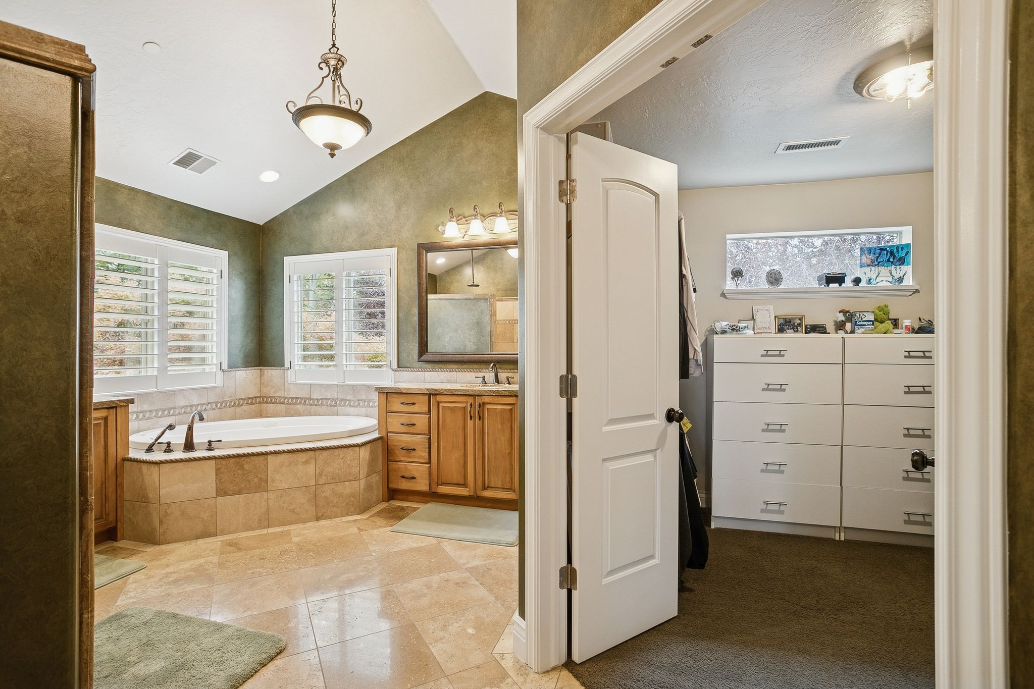 Bathroom featuring vaulted ceiling, a bath, vanity, and light tile patterned floors