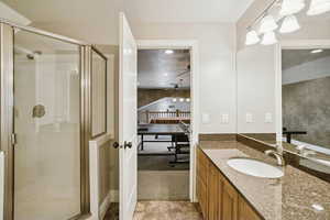 Bathroom with light carpet, vanity, a shower stall, and a textured ceiling
