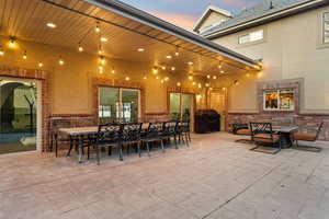 Patio terrace at dusk with outdoor dining space, a patio area, and a grill