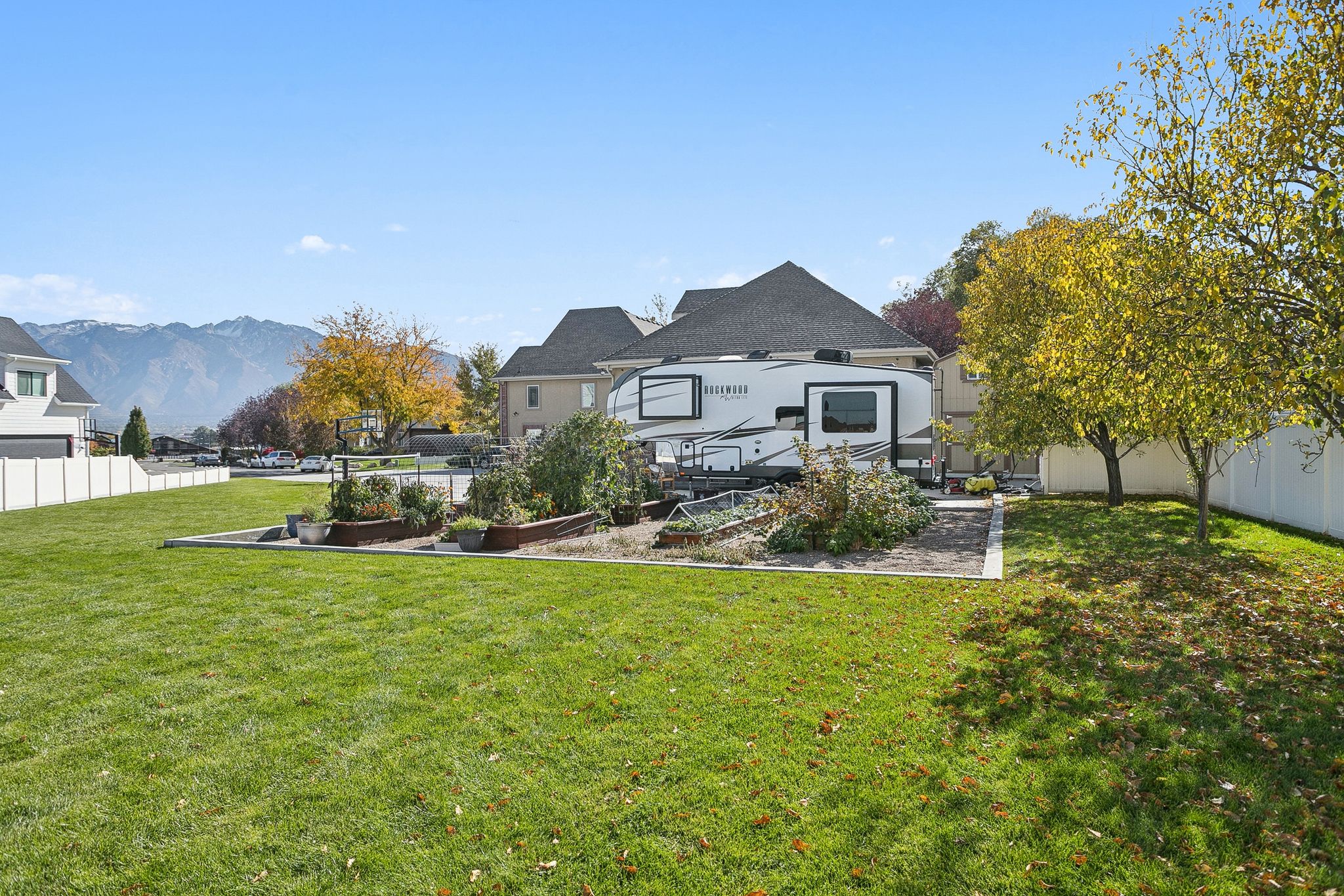 Back of house with a fenced backyard and a garden