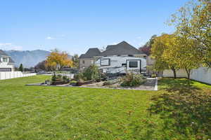 Back of house with a fenced backyard and a garden