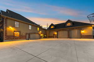 View of front of house with brick siding, concrete driveway, and a shingled roof