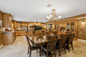 Dining space with a chandelier, light tile patterned floors, and recessed lighting