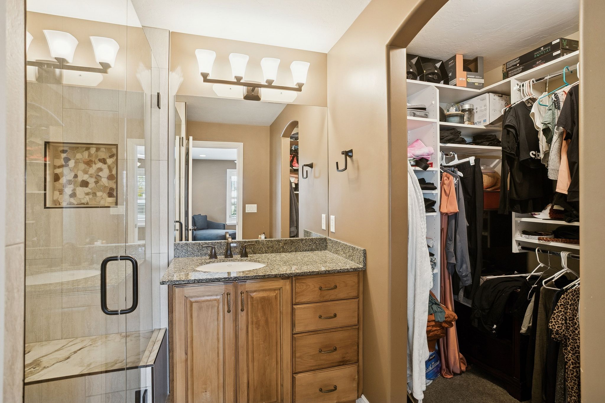 Bathroom with vanity, a shower stall, a walk in closet, and connected bathroom