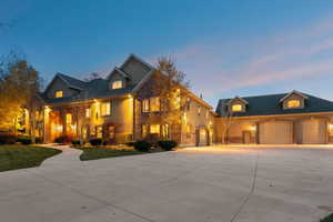 View of front of property featuring concrete driveway, stone siding, an attached garage, and a front yard