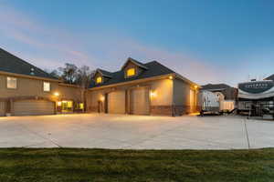 View of front of home featuring concrete driveway, stone siding, and a garage