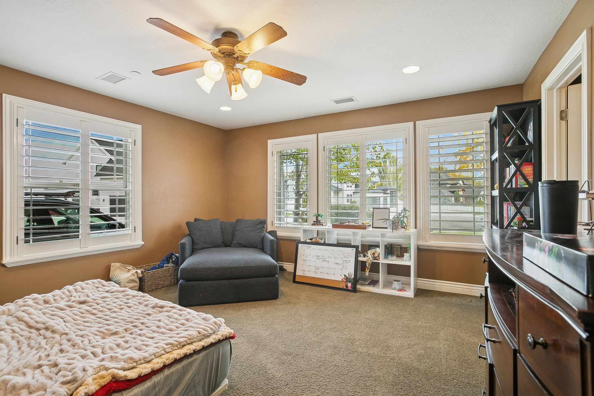 Bedroom with multiple windows, light colored carpet, ceiling fan, and recessed lighting