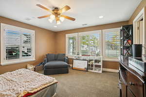 Bedroom with multiple windows, light colored carpet, ceiling fan, and recessed lighting