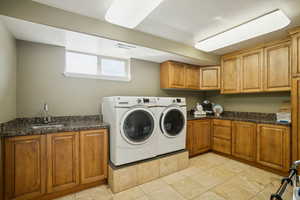 Laundry area featuring separate washer and dryer and cabinet space